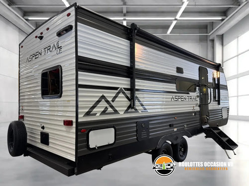 Vue arrière de la Dutchmen Aspen Trail 23BH 2026, côté porte, avec auvent et roue de secours.