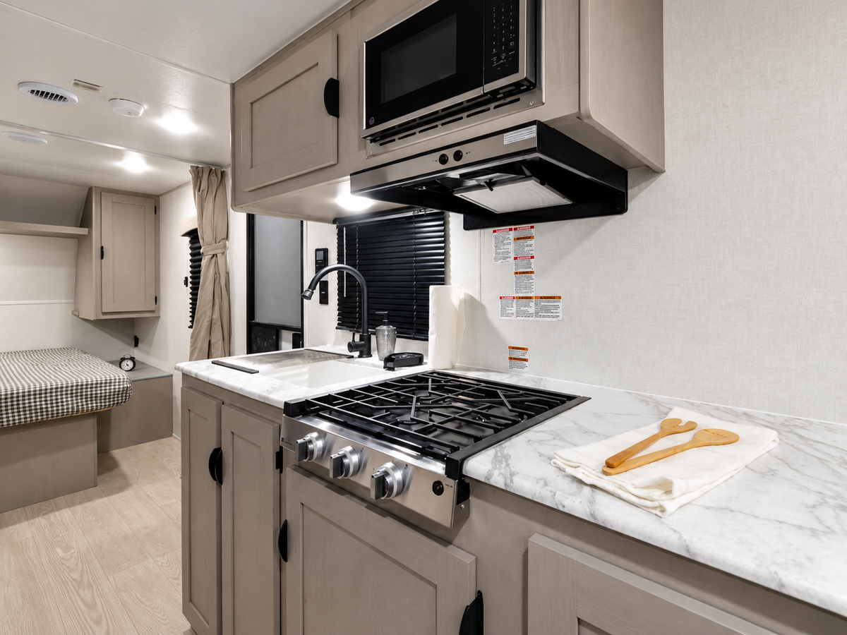Cuisine intérieure avec évier, plaque de cuisson, micro-ondes, réfrigérateur et armoires dans la Viking 242MK 2027.