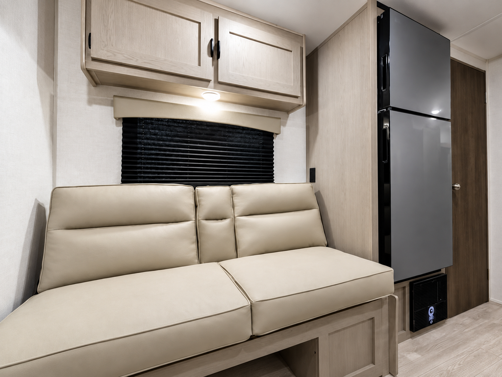 Sofa arrière de la Viking 242MK 2027, avec armoires au-dessus et réfrigérateur à proximité.