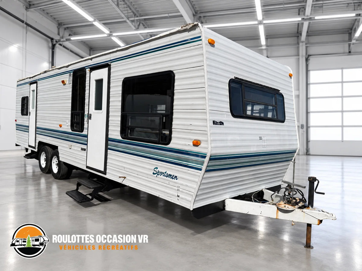Roulotte Sportsmen 3000 vue de trois quarts avant, avec deux portes d’entrée, grandes fenêtres et attelage.