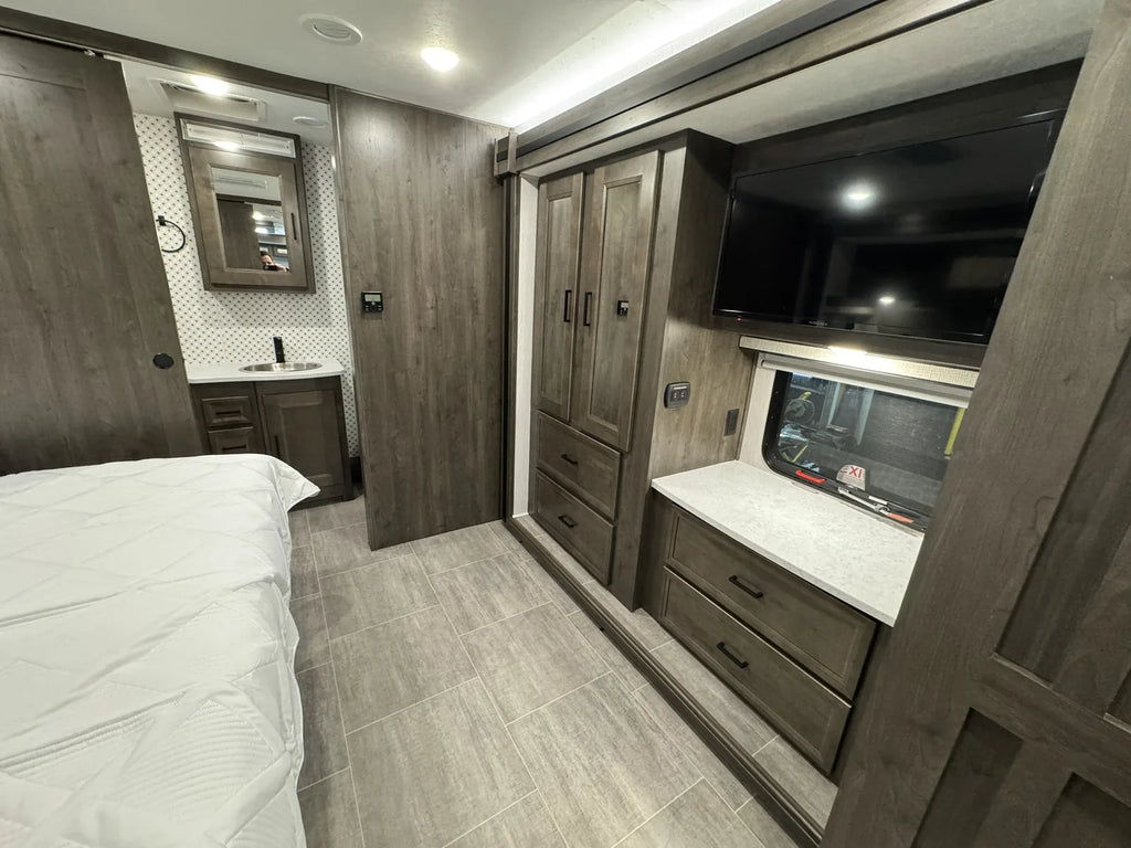 Chambre avec télévision, penderie et rangements.