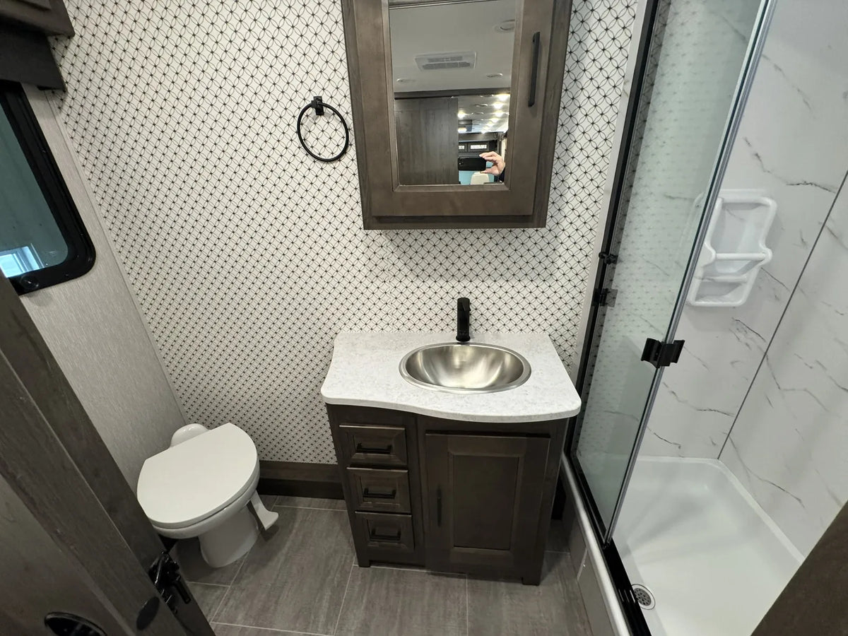 Salle de bain avec lavabo, toilette et douche.