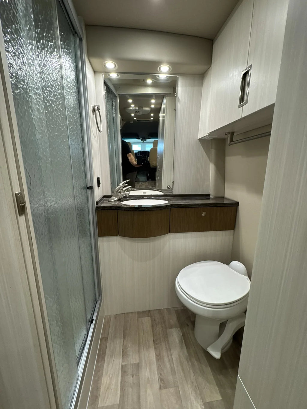 Salle de bain avec toilette, lavabo et douche.