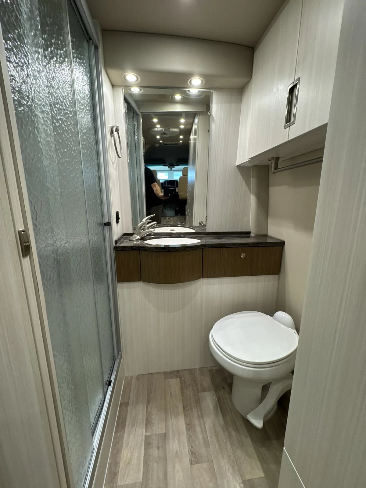Salle de bain avec toilette, lavabo et douche.