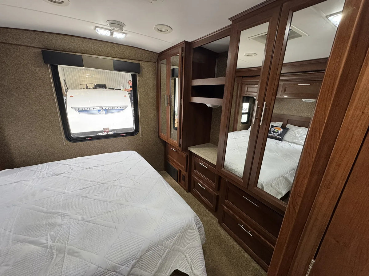Chambre avec lit, fenêtre et armoires de rangement.