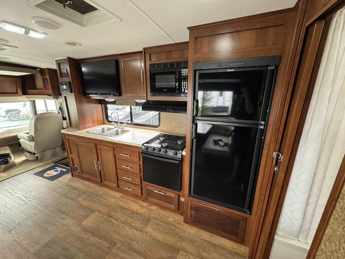 Cuisine avec réfrigérateur, cuisinière, micro-ondes et évier.