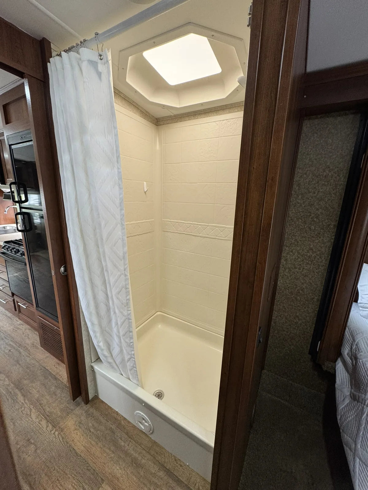 Cabine de douche avec rideau et puits de lumière.