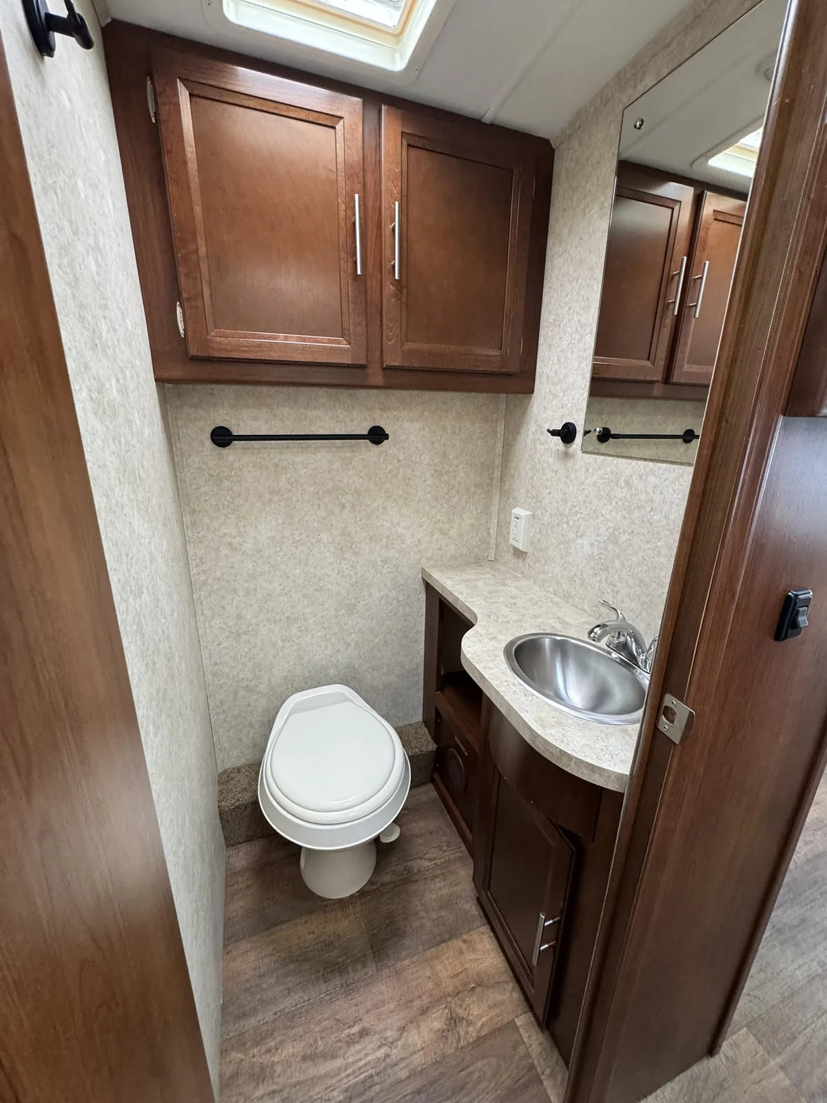 Salle de bain avec toilette, lavabo et armoire.