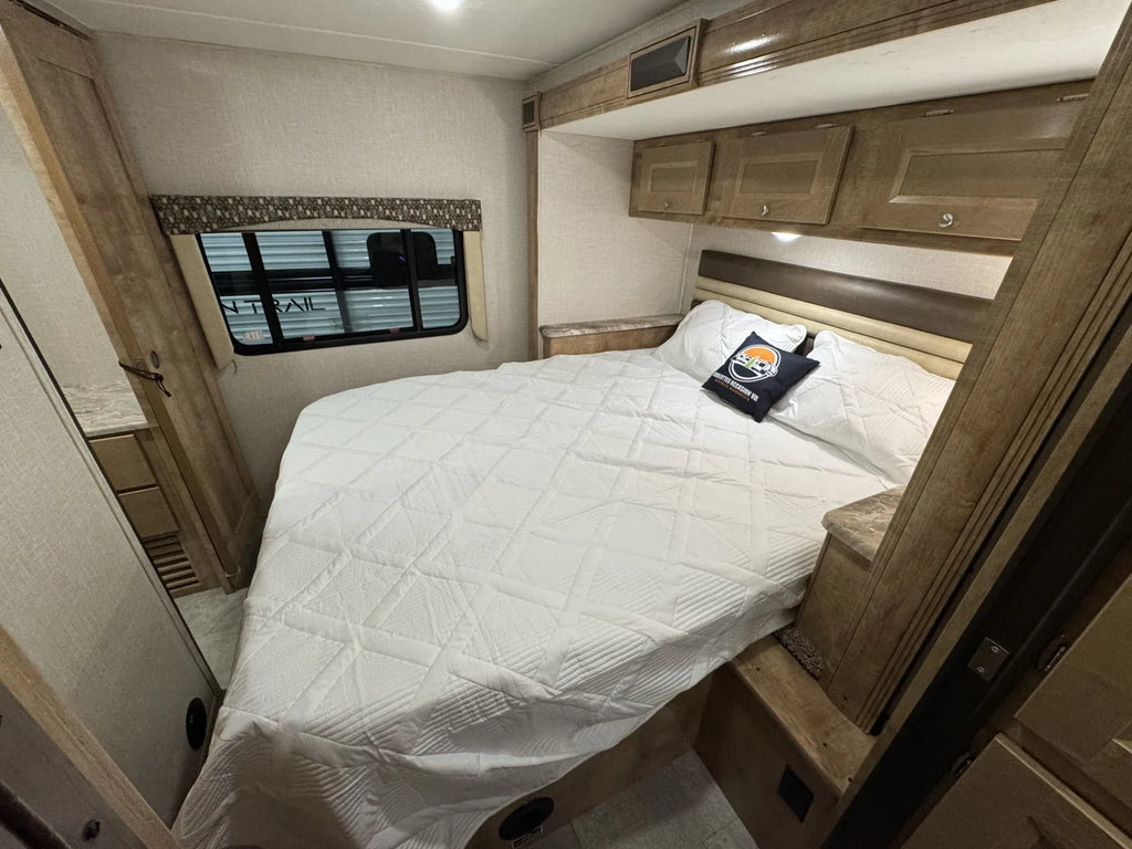 Chambre du Coachmen Leprechaun 311FS 2020 avec lit et armoires de rangement.