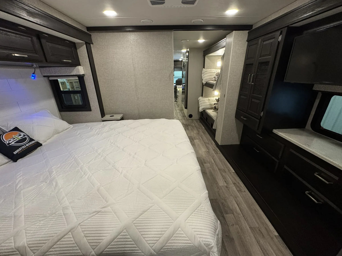 Chambre du motorisé Jayco Precept 36A 2023 avec lit et armoires de rangement.