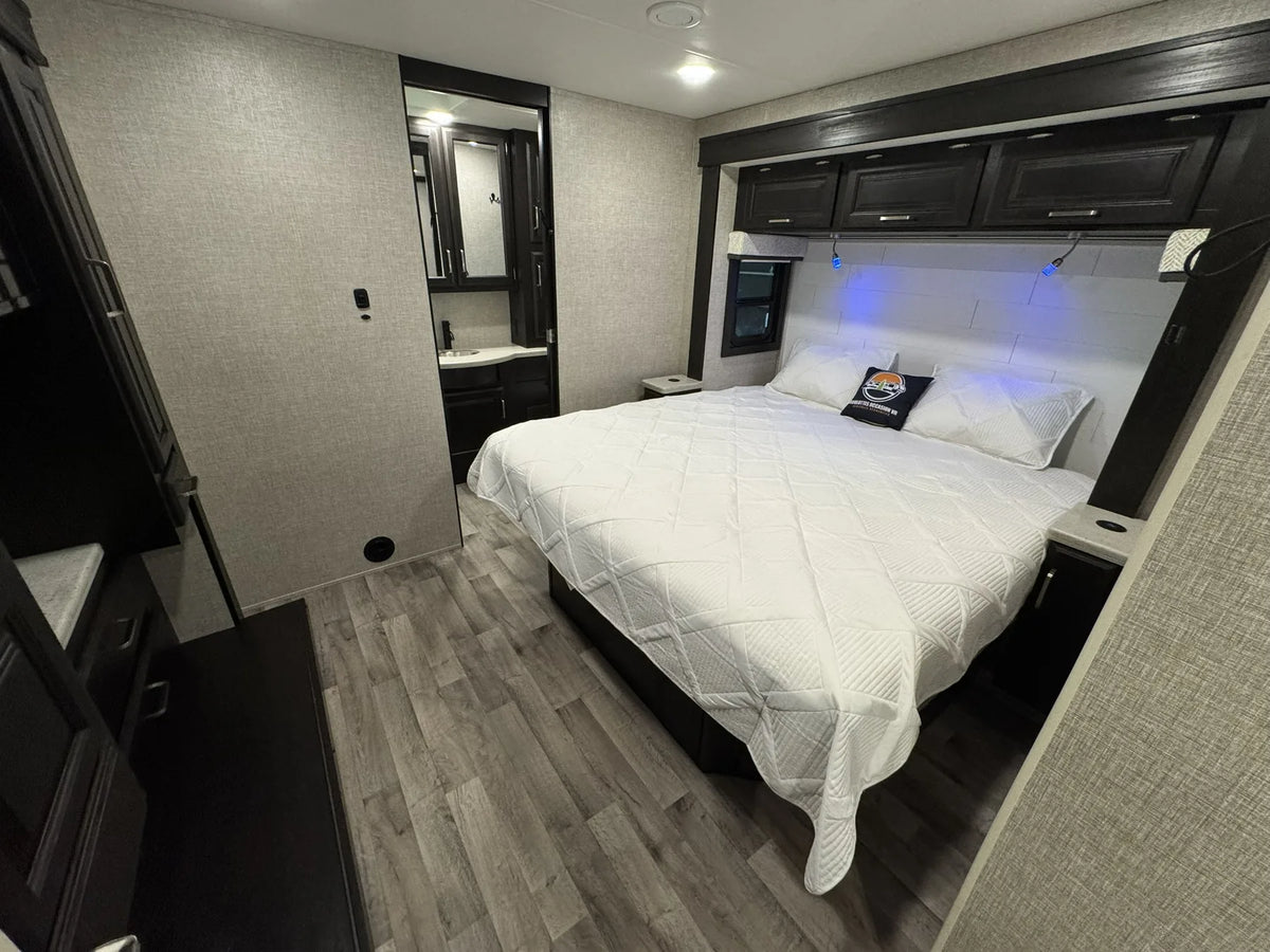 Chambre du Jayco Precept 36A 2023 avec grand lit et rangements au-dessus de la tête de lit