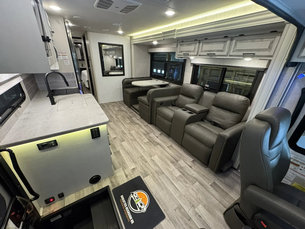 Salon du Jayco Precept 36A 2023 vu depuis la cuisine, avec sofa et fauteuils.