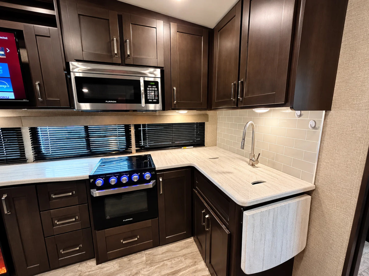 Cuisine de la Reflection 28BH 2021 avec cuisinière, four, micro-ondes, évier et rallonge de comptoir rabattable.