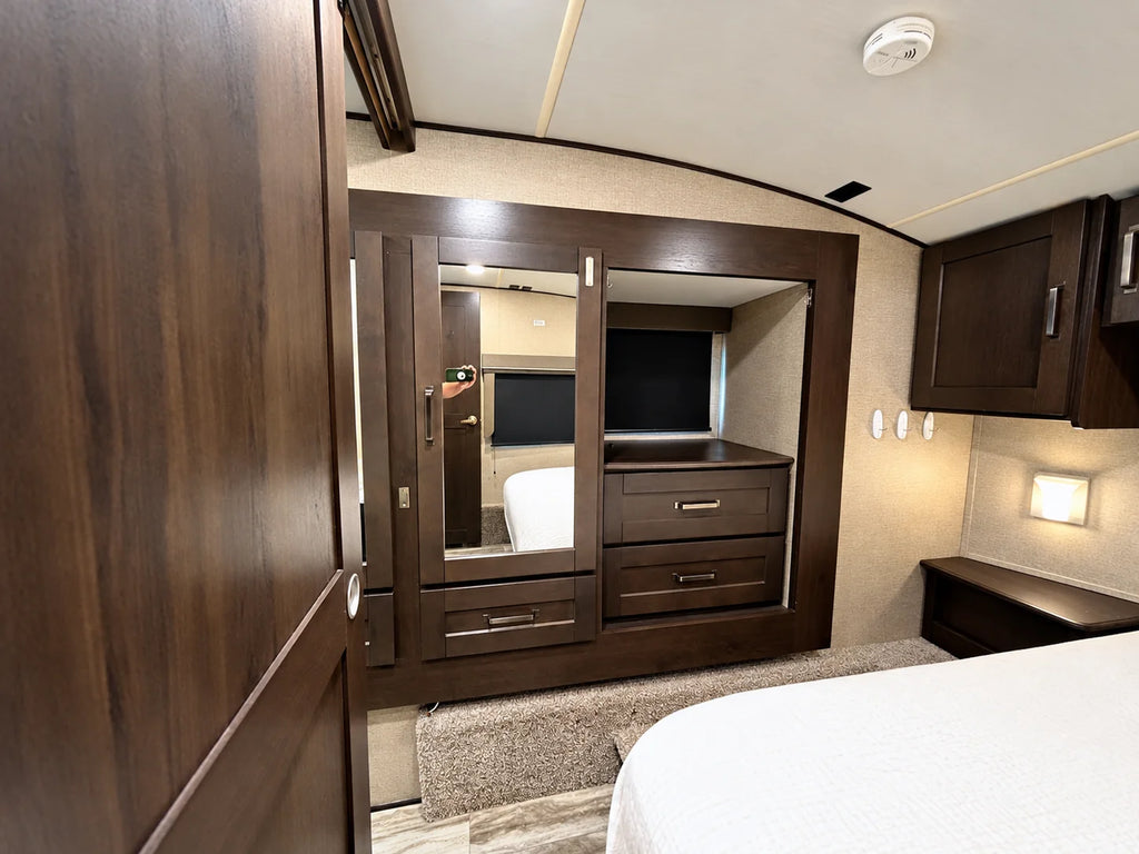 Garde-robe avec porte miroir et tiroirs intégrés dans la chambre principale de la Reflection 28BH 2021.