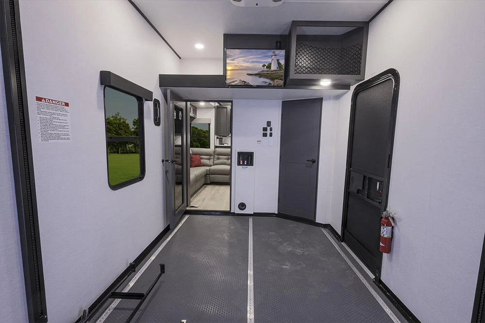 Garage cargo de la Alliance Valor 44V14 2024 avec rails d’arrimage, mezzanine et accès au salon.