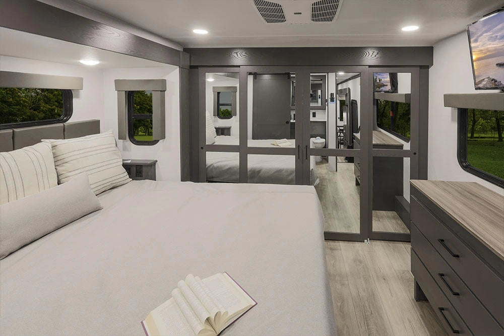 Chambre principale de la Alliance Valor 44V14 2024 avec grand lit, garde-robe à miroirs et commode.