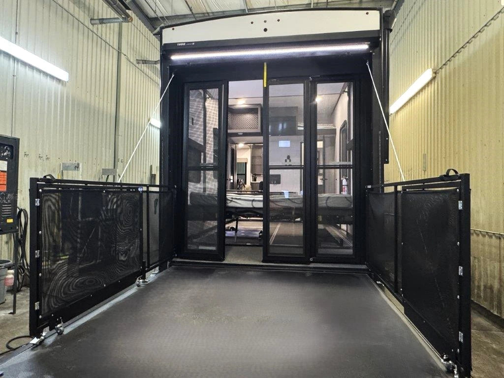 Vue arrière de la Alliance Valor 44V14 2024 avec rampe abaissée en patio, garde-corps et portes vitrées.